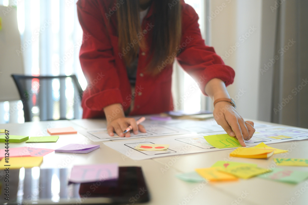 Close up of designers discussing app layout and interface wireframes during a brainstorming session Close up of designers discussing app layout and interface wireframes during a brainstorming session