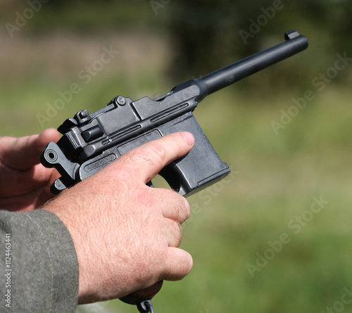 Cocking action of small military pistol sidearm. photo