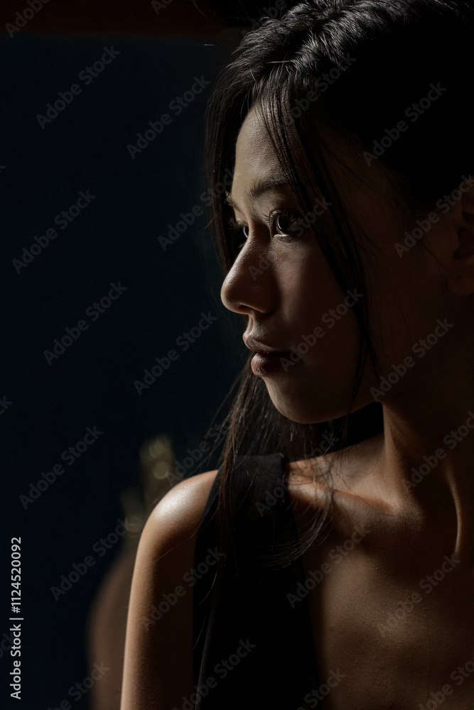 Fototapeta premium 黒いドレスを着た若い女性の雰囲気のあるポートレート