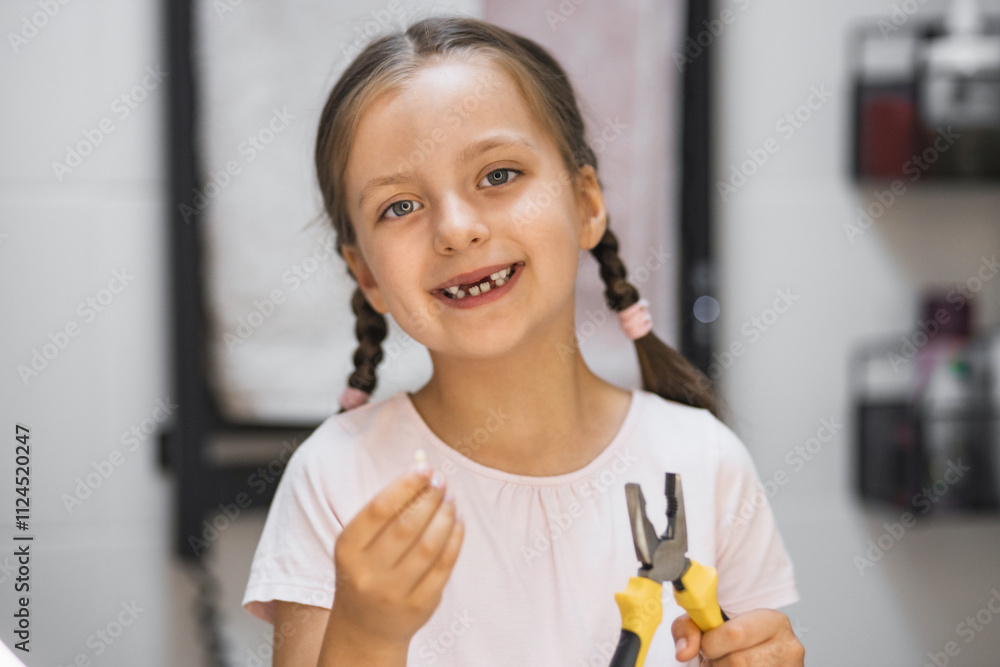 Little Caucasian girl holding a fallen baby tooth with pliers, looking in bathroom mirror. She smiles, showing missing tooth, representing childhood milestones and dental health. Little Caucasian girl holding a fallen baby tooth with pliers, looking in bathroom mirror. She smiles, showing missing tooth, representing childhood milestones and dental health.