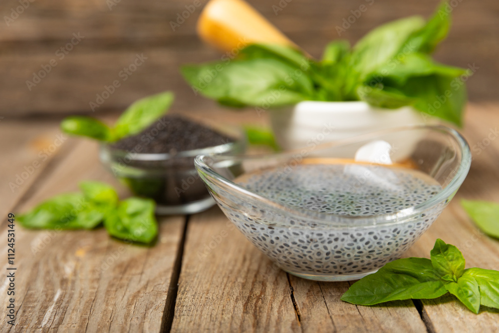 Basil seeds on textured wooden background. Close-up. Superfood. Ocimum basilicum. Organic basil seeds. selasih. Space for text. Copy space. Basil seeds on textured wooden background. Close-up. Superfood. Ocimum basilicum. Organic basil seeds. selasih. Space for text. Copy space.