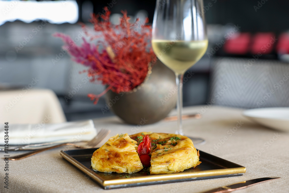 Elegant presentation of a potato omelet with a glass of wine Elegant presentation of a potato omelet with a glass of wine