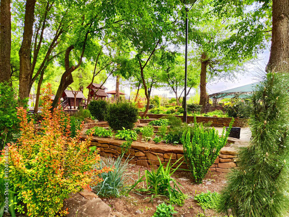 Naklejka premium Vibrant garden filled with lush greenery and colorful plants in a tranquil outdoor setting