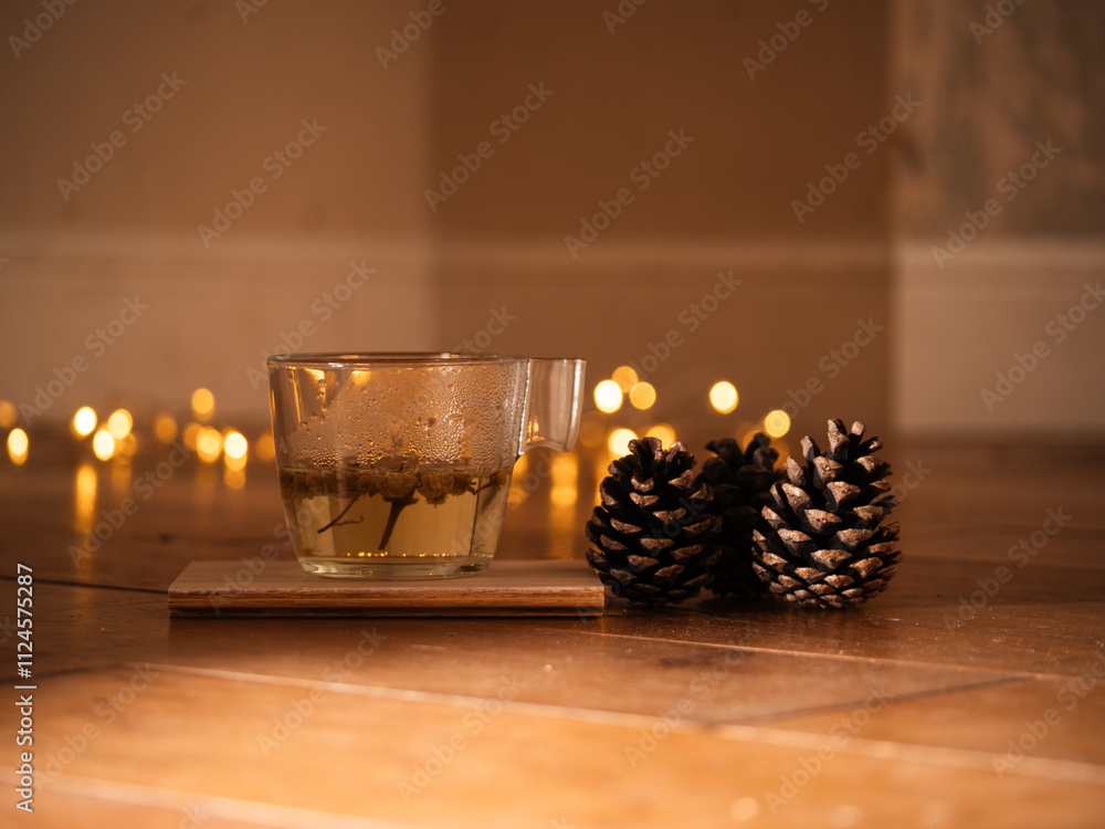 Cup of chamomile tea with pine cones with twinkling lights bokeh Cup of chamomile tea with pine cones with twinkling lights bokeh