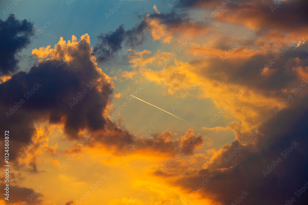 Airplane contrail through colorful clouds at sunset in W�rzburg. Airplane contrail through colorful clouds at sunset in W�rzburg.