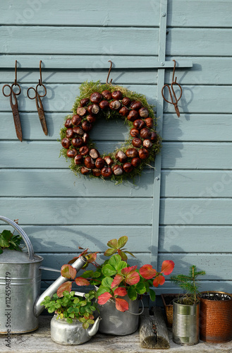 Autumn garden decor with chestnut wreath and gardening tools photo