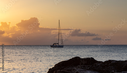 Beautiful sunset in Vieste, Apulia with a boat on the horizon and rocks in the foreground photo