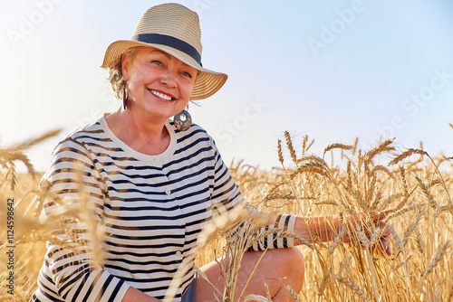 Smiling mature woman amidst wheat crops in farm
