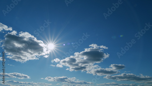 Rays of the sun make their way through the clouds at blue sky. Sunlight with sunbeams. Timelapse.