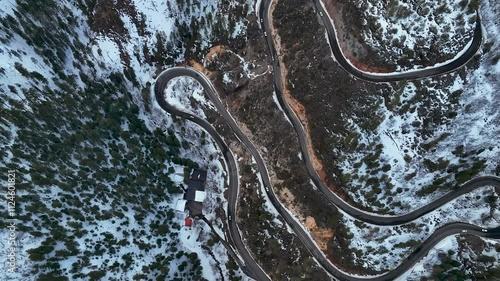 Winding Road Through The Mountain Covered With Snow During Winter. - aerial shot photo