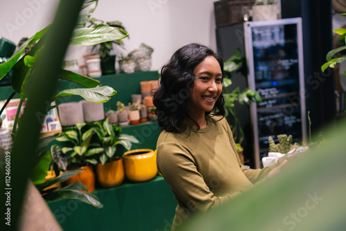 Smiling florist working in a plant-filled flower shop photo