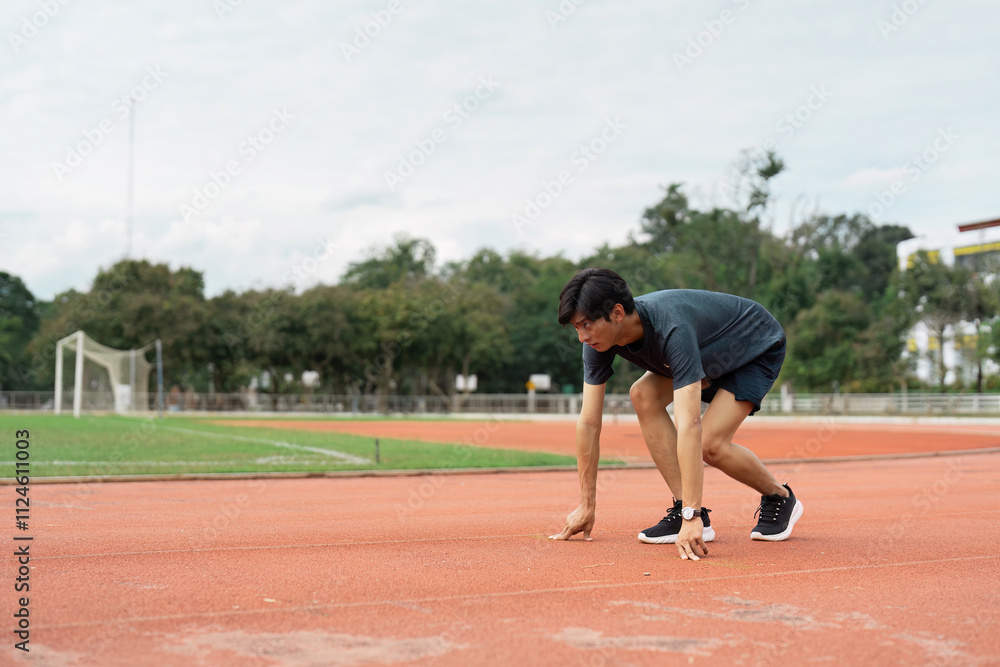 Athlete preparing to sprint sports track action outdoor stadium low angle view focus on determination Athlete preparing to sprint sports track action outdoor stadium low angle view focus on determination
