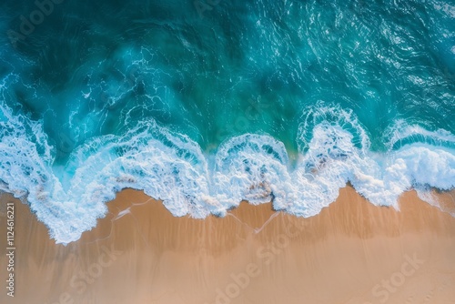 Gentle waves lap against the golden sands of a pristine beach, illuminated by sunlight, offering a serene view of the ocean's rhythmic movement and vibrant colors.