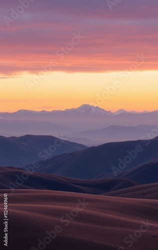 Serene Sunset Over Rolling Mountains And Distant Peak