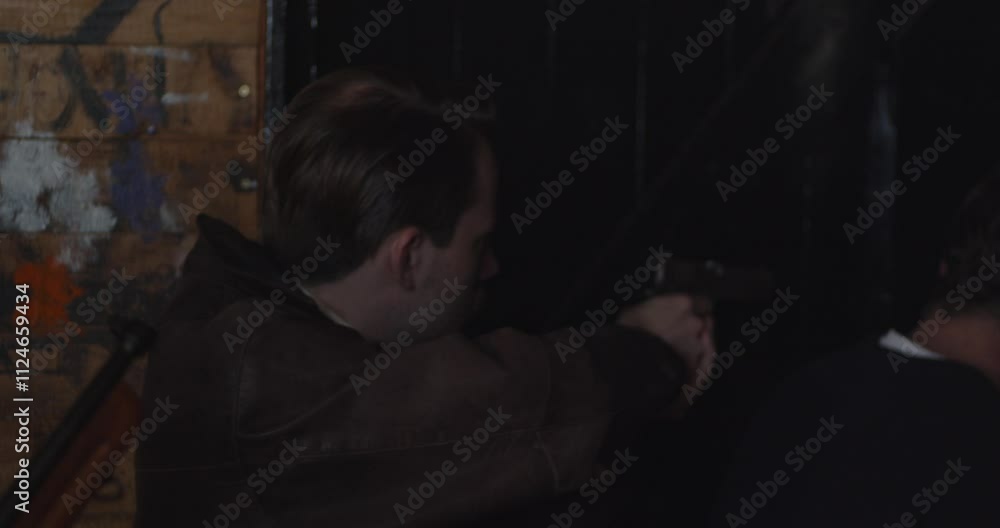 Prohibition era concept - Close up of a man stacked up at a door and aiming his pistol at the entrance Prohibition era concept - Close up of a man stacked up at a door and aiming his pistol at the entrance