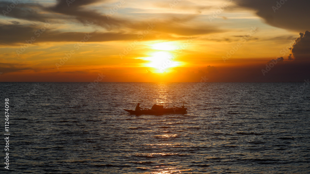 Fototapeta premium Traditional Indonesian fishing boat. Horizon line between sky and sea. Dramatic sunset and clouds.