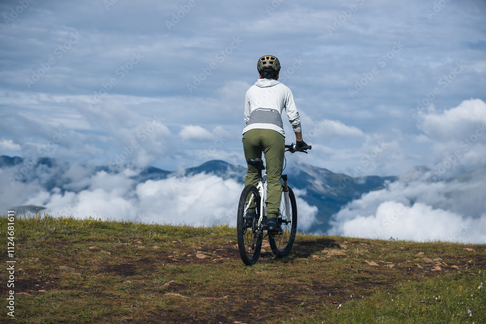 Asian woman riding a mountain bike down hill on beautiful mountain top
