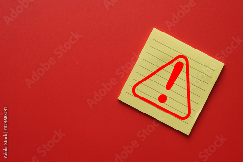 Attention Sign on yellow lined sticky note on red background for Safety, Alert, and Warning.,Symbolizing Danger,Risk Prevention.,Safety Awareness. photo