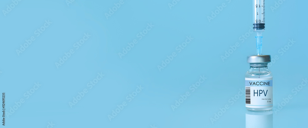 HPV Vaccine in a bottle with a syringe on a blue background. Experimental HPV vaccine vial for immunization against HPV disease. Copy space HPV Vaccine in a bottle with a syringe on a blue background. Experimental HPV vaccine vial for immunization against HPV disease. Copy space