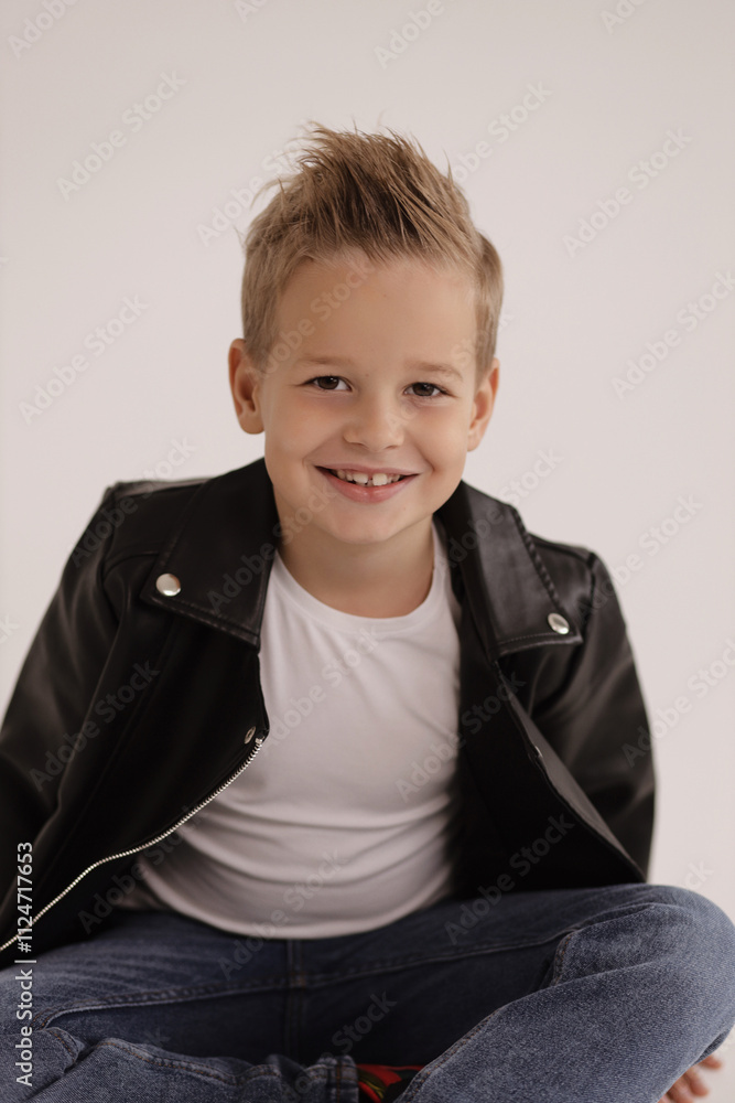 cute boy with blond hair wearing leather jacket and jeans posing in studio cute boy with blond hair wearing leather jacket and jeans posing in studio