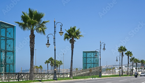 Avenue Mohamed VI, Tanger, Tangier, Morocco. Palm trees, traffic, road, perfect blue sky. photo