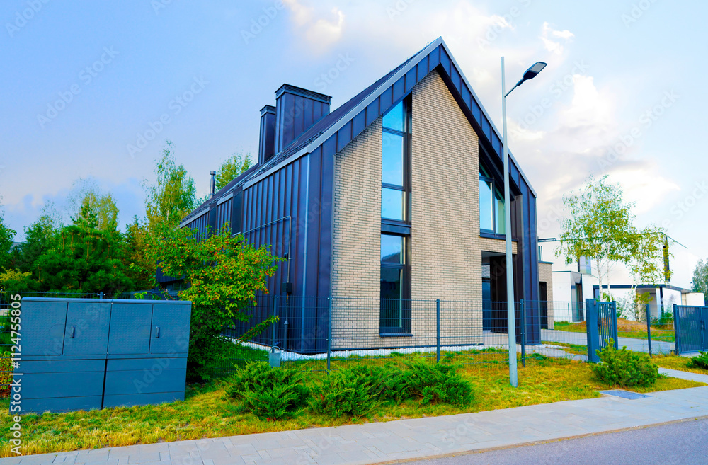 Obraz premium Barn House in suburban area. Ultra modern Architect-designed luxury house in suburb. Private Wooden Scandi home. Modern Scandinavian Barnhouse. Contemporary barnhouse villa. Barn House with fence.