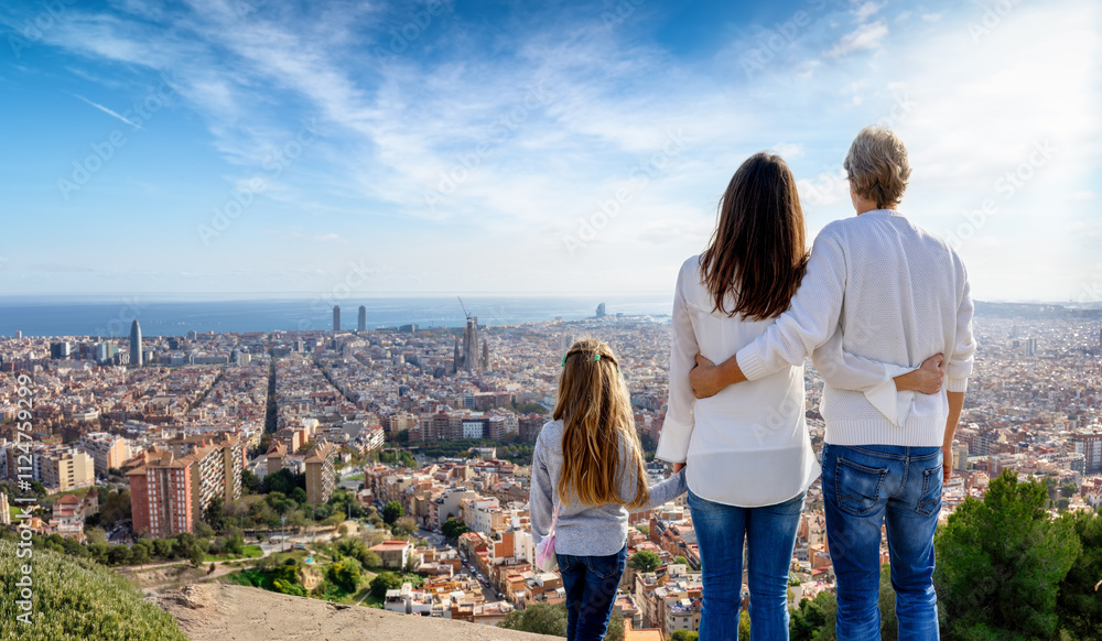 A tourist family enjoys the panoramic view of the skyline of Barcelona, Spain, during their city trip vacation