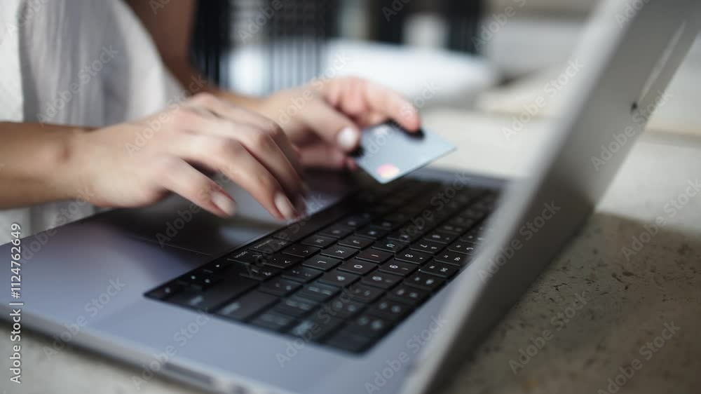 Close-up of female hands entering card details on a laptop, followed by cash banknotes appearing. Concept of online payments, e-commerce, digital transactions and credit. Close-up of female hands entering card details on a laptop, followed by cash banknotes appearing. Concept of online payments, e-commerce, digital transactions and credit.