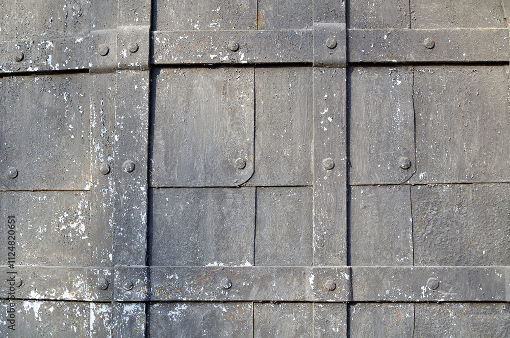 Texture metal background with grunge surface - dark old hammered metal plates with rivets and stripes on them Texture metal background with grunge surface - dark old hammered metal plates with rivets and stripes on them