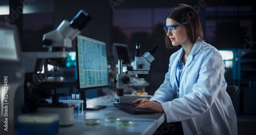 Caucasian Female Scientist Working on a Computer in the Evening. Specialist Using a Gene Sequencing Software. Advanced Biotechnology Lab in a Medical Research and Development Center