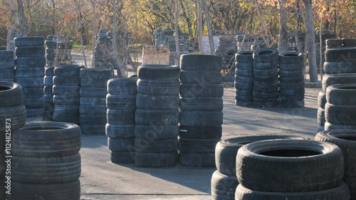 Outdoor tactical field for paintball and airsoft, designed with stacked car tires and natural elements. Perfect for adrenaline-packed team games, strategic combat training, and outdoor recreation.