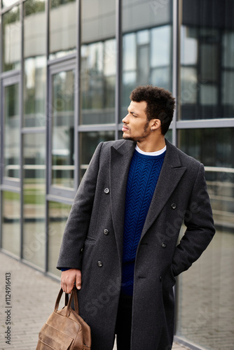 A well dressed man with a confident expression strolls by a contemporary glass building.