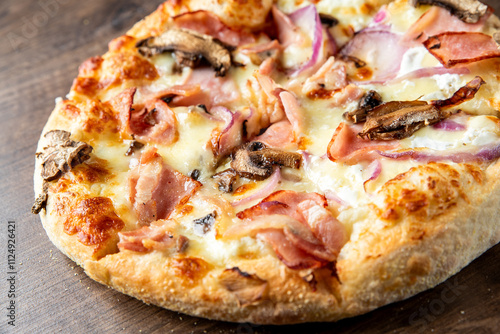 Delicious freshly baked pizza topped with ham, mushrooms, and red onions, featuring a golden crust and melted cheese. Perfect for food lovers and culinary enthusiasts. photo