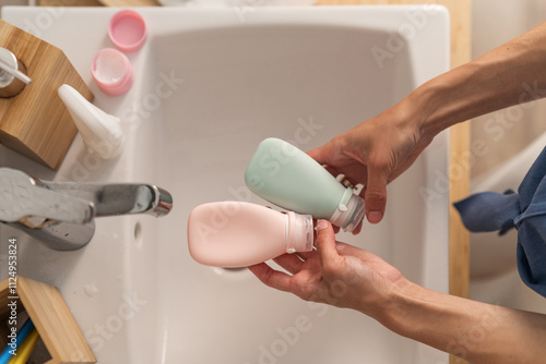 Top view woman holding bottles of skin care cosmetics. Daily home beauty routine