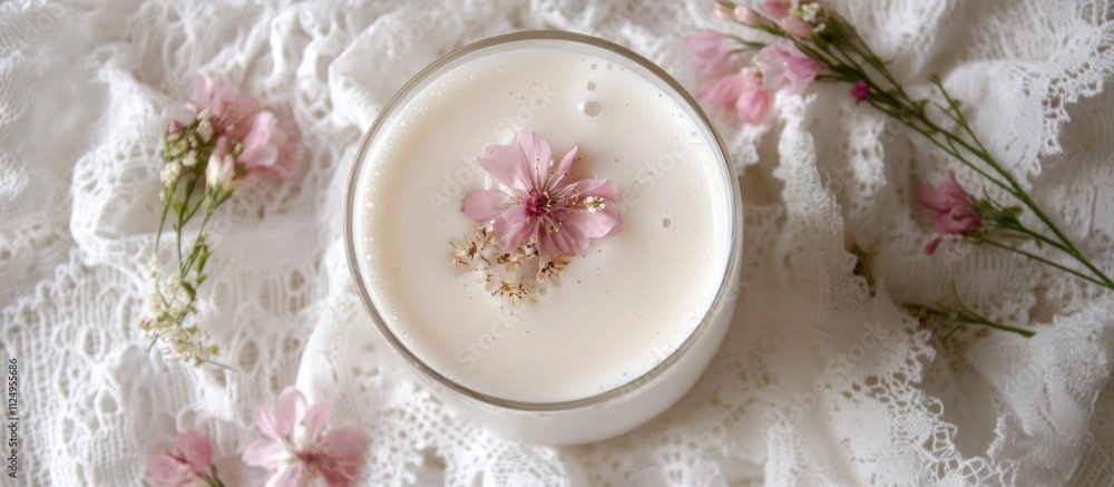 A milk drink with delicate floral garnishes, on a white lace tablecloth A milk drink with delicate floral garnishes, on a white lace tablecloth