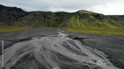 Black SUV crosses shallow muddy river in Iceland during road trip