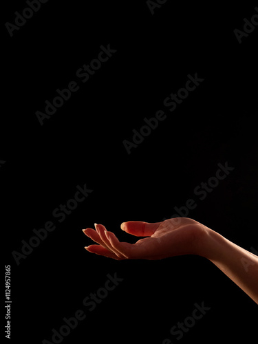 woman's hand palm facing up, black background
