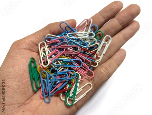 colorful paper clips on a male hand on the white background