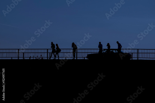 people and acar crossing a bridge