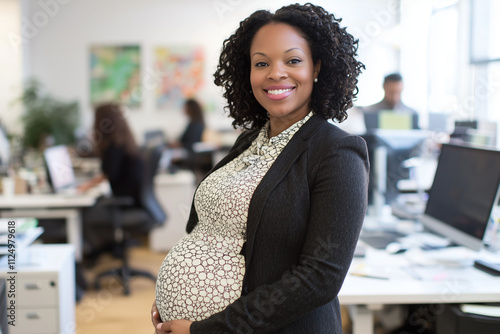 A smiling pregnant Black businesswoman in a professional office environment, wearing a formal outfit. The workplace includes computers, papers, and a busy atmosphere in the background
