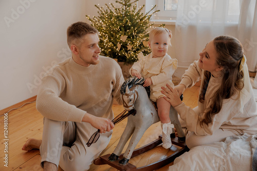 Family with a baby girl on a toy horse on New Year's Eve