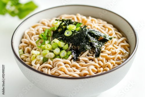 clean and modern bowl of soba noodles garnished with seaweed and scallions styled on minimalist white background photo