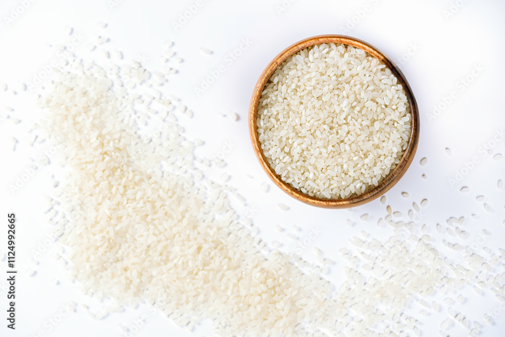 Wooden bowl with rice on white background with scattered grain. Healthy nutrition and light breakfast. Wooden bowl with rice on white background with scattered grain. Healthy nutrition and light breakfast.