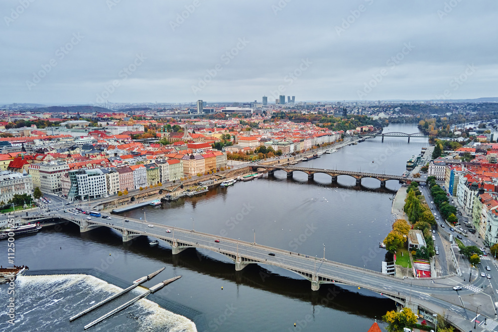 Fototapeta premium Panoramic aerial view of European city with multiple bridges over river, colorful historic buildings. Cityscape of Prague, Czech Republic