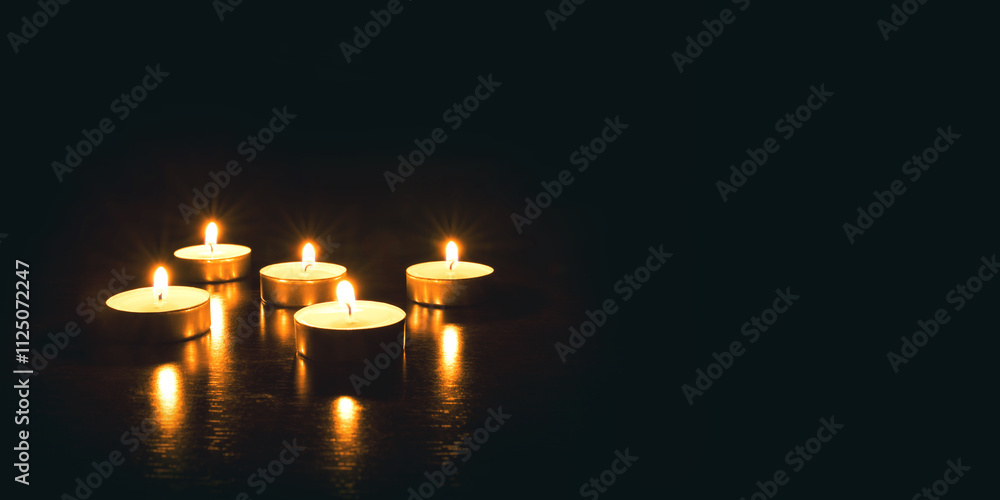 Several burning candles on a black background. Banner with copy space. Several burning candles on a black background. Banner with copy space.