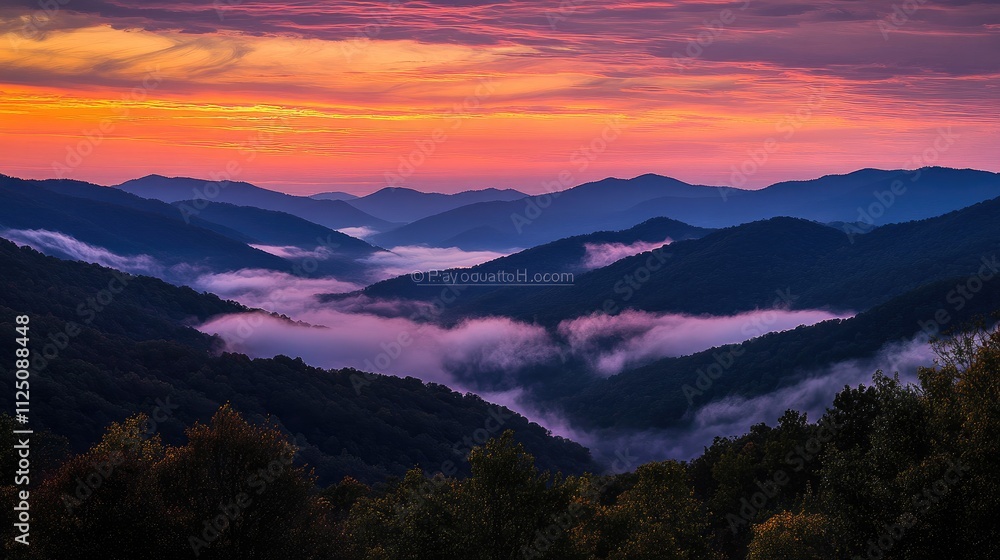 Obraz premium A silhouette of mountains against a colorful sunrise sky, with layers of clouds and mist creating a dramatic and serene scene, perfect for nature enthusiasts