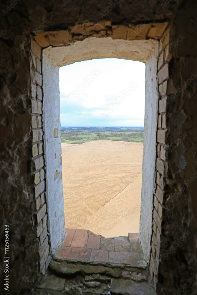 Obraz premium view from the small window of an ancient tower overlooking the plain and the desert