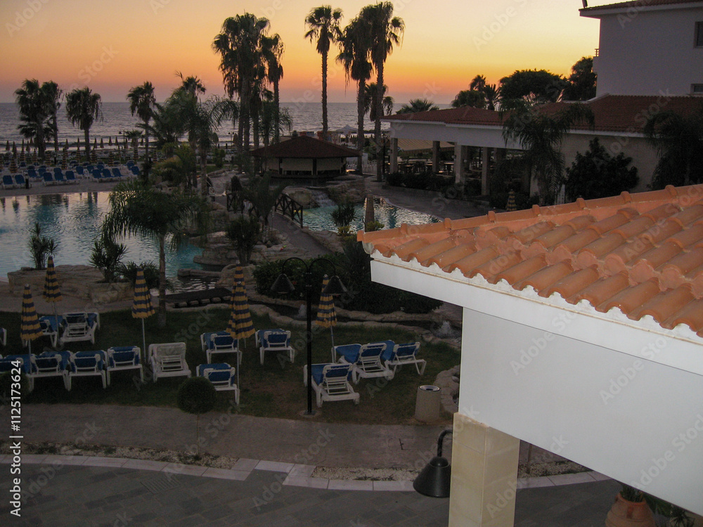 Fototapeta premium Sunset over pool at coastal resort