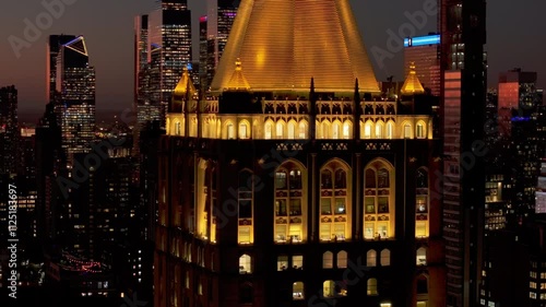 Golden light bathes New York Life Building art deco skyscraper in Madison Avenue in Rose Hill and NoMad neighborhoods of Manhattan, NYC