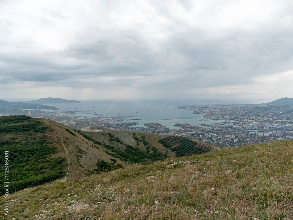 Naklejka premium Panoramic view of Novorossiysk City and Tsemess Bay at sunrise. Morning cityscape of large port at Black Sea coast in Russia